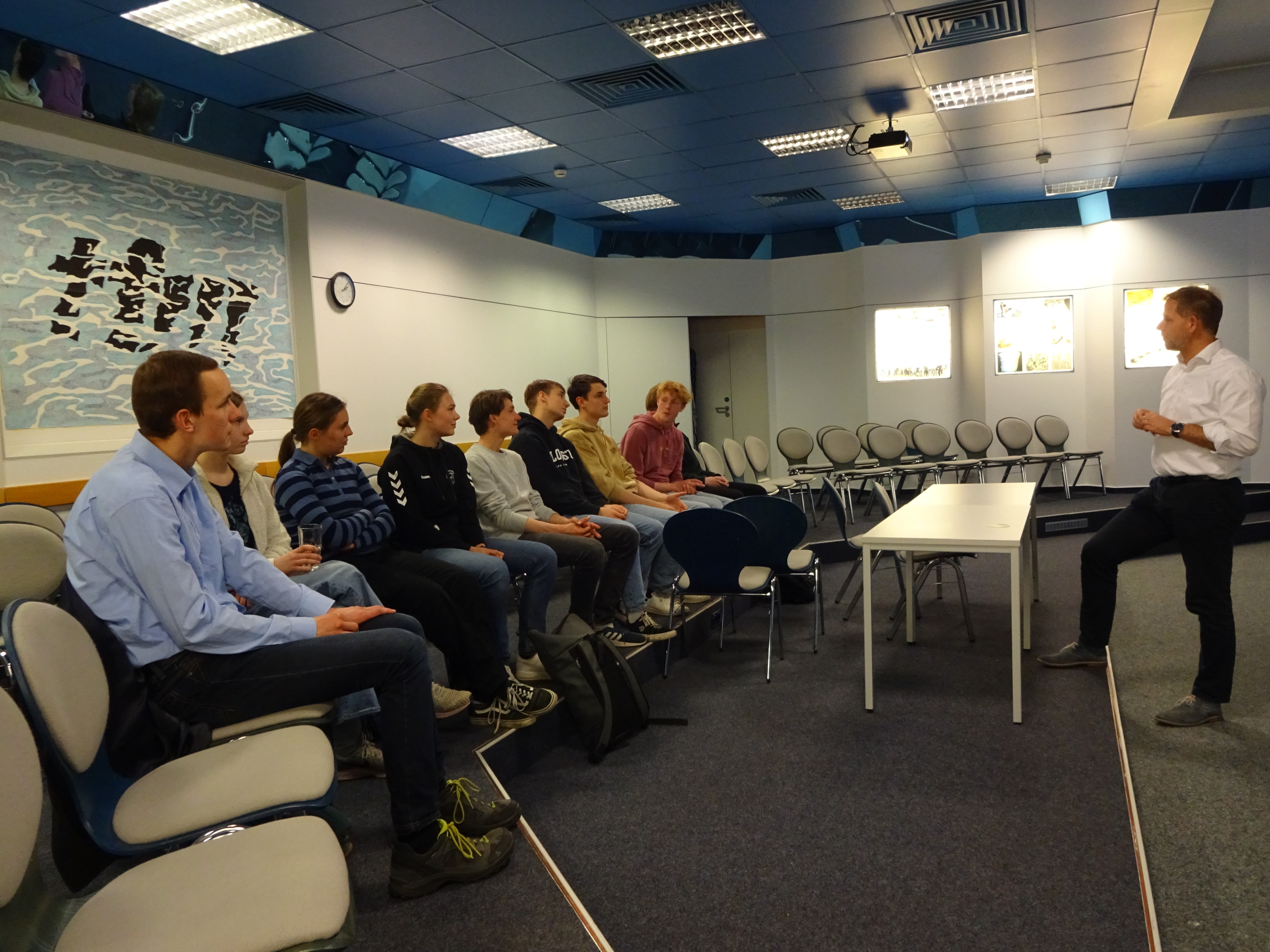 Die Schülerinnen und Schüler sitzen in der Kieler Forschungswerkstatt und hören dem Vortrag von Prof. Dr. Gerhard Schmidt zu.
