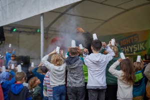 Kinder von hinten mit Papierhüten auf.