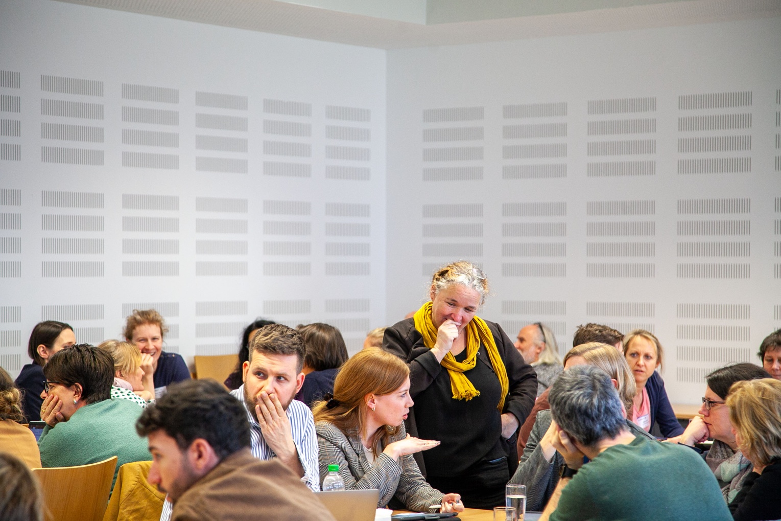 Ein Raum in dem Lehrkräfte an tischen sitzen und miteiander arbeiten.